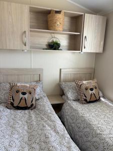 two beds sitting next to each other in a bedroom at Dotties Den at Sunnysands in Llanddwywe