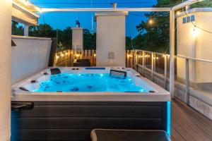 a jacuzzi tub on a balcony at night at Nautica Resort in Giżycko