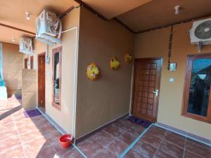 a corner of a room with a door and a tile floor at Penginapan Griya Safira in Taliwang