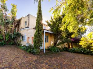 an exterior view of a house with trees at Aurora Guest Units in Durbanville