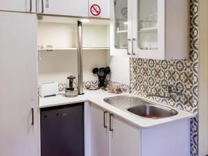 a small kitchen with white cabinets and a sink at Aurora Guest Units in Durbanville +47 photos