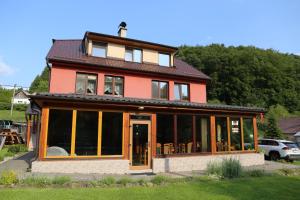 a house with large windows and a roof at Penzion Chřiby in Staré Hutě
