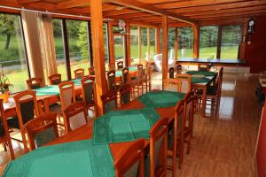 a dining room with green tables and chairs at Penzion Chřiby in Staré Hutě