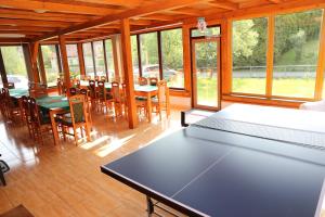 a dining room with a table and chairs and windows at Penzion Chřiby in Staré Hutě