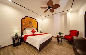 a bedroom with a large bed and a red chair at Lake Hotel Sóc Sơn in Sóc Sơn