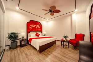 a bedroom with a red bed and a red chair at Lake Hotel Sóc Sơn in Sóc Sơn