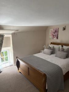 a bedroom with a large bed and a window at The Cottage in Sulgrave