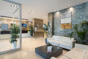 a lobby with a couch and potted plants at Smy Bologna Centrale in Bologna