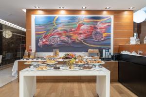 a table with plates of food on it with a painting at Smy Bologna Centrale in Bologna +69 photos