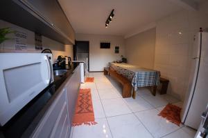 a room with a kitchen with a sink and a counter at Pousada Maria Eduarda in Guarda do Embaú