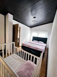 a bedroom with two beds and a wooden ceiling at Kućica Sreće in Visoko +19 photos
