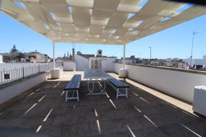 a patio with a table and chairs on a roof at Dimora storica Jolanda a Uggiano in Uggiano la Chiesa
