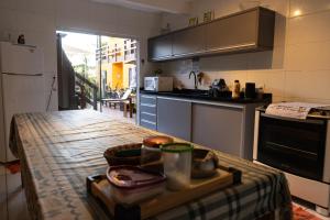 a kitchen with a table with a tray of food on it at Pousada Maria Eduarda in Guarda do Embaú
