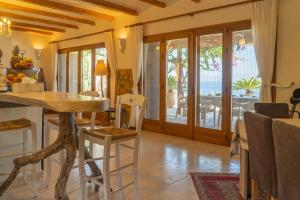 a kitchen and dining room with a table and chairs at Villa Mirabello Tholos Adults Only in Kavoúsion