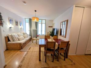 a living room with a table and a couch at Cocon Luchon in Luchon