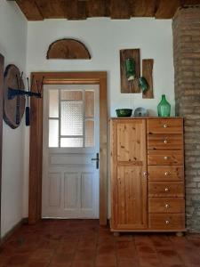 a room with a door and a dresser with a window at Jakabhegy vendégház in Szenna
