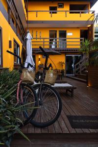 a bike parked on a deck with an umbrella at Pousada Maria Eduarda in Guarda do Embaú
