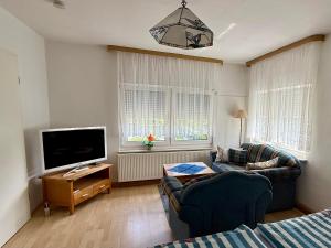 a living room with two couches and a flat screen tv at Rosenhof in Binz in Binz