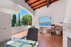 a living room with a table and chairs on a patio at Villa Le Ginestre di mare in Capoliveri