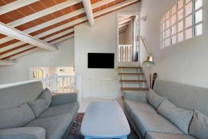 a living room with a couch and a tv at Villa Le Ginestre di mare in Capoliveri