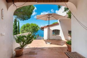 an entrance to a house with an umbrella at Villa Le Ginestre di mare in Capoliveri