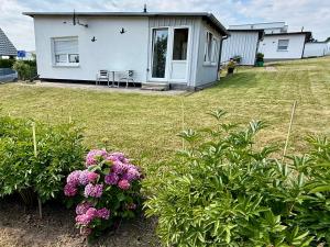 a white house with some flowers in a yard at Rosenhof in Binz in Binz