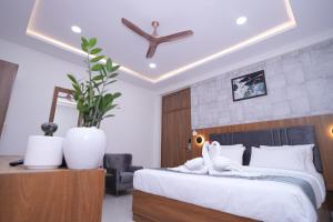 a bedroom with a bed with a white bedspread at 69th Heaven Hotel in Devanhalli