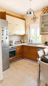a kitchen with wooden cabinets and a stainless steel refrigerator at Angela's House in Nea Plagia