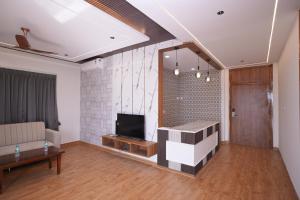 a living room with a couch and a television at 69th Heaven Hotel in Devanhalli