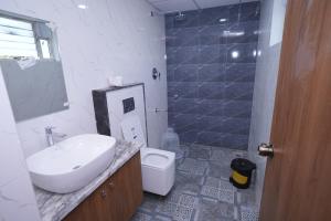 a white bathroom with a sink and a toilet at 69th Heaven Hotel in Devanhalli +46 photos