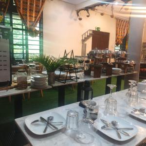 a table with plates and silverware on top of it at Da Palm boutique resort in Aburi
