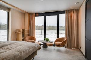 a bedroom with a bed and a table and chairs at OplooPark Forrest Villa in Oploo