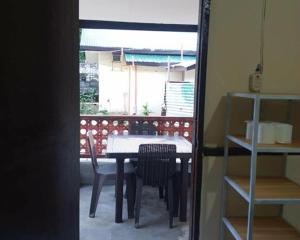 a dining room with a table and chairs and a window at Bale Cabugao Cottages Rental El Nido overlooking Beach in El Nido