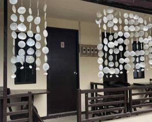 a room with a black door and a bunch of white decorations at Bale Cabugao Cottages Rental El Nido overlooking Beach in El Nido