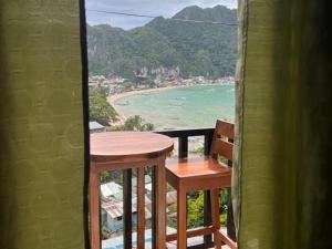 a table and chairs on a balcony with a view of the beach at Bale Cabugao Cottages Rental El Nido overlooking Beach in El Nido