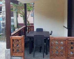 a black table and chairs on a porch at Bale Cabugao Cottages Rental El Nido overlooking Beach in El Nido