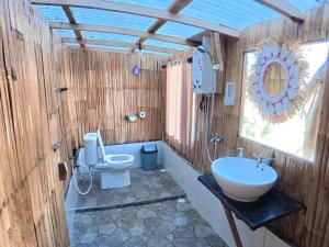 a bathroom with a toilet and a sink at Wanagiri sunset glamping in Gitgit