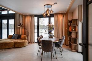 a living room with a table and chairs and a couch at OplooPark Forrest Villa in Oploo +40 photos