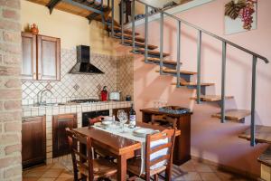 a kitchen with a table and a spiral staircase at Tenuta la Selva Casa I Lavatoi in Casal Velino +1 photo