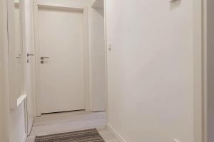 a white hallway with a door and a rug at Mosel Appartment in Briedel in Briedel