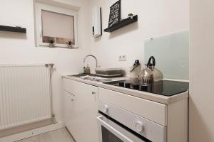 a white kitchen with a stove and a sink at Mosel Appartment in Briedel in Briedel