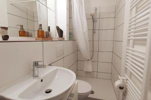 a white bathroom with a sink and a toilet at Mosel Appartment in Briedel in Briedel
