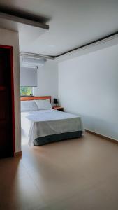 a bedroom with a bed and a large window at Hotel Pacaraima in Mecalineta