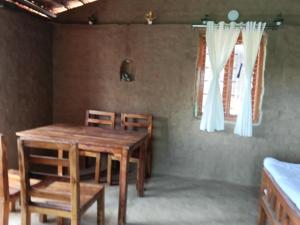 a dining room with a wooden table and chairs at Ishika Homestay in Maheshwar