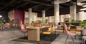 a restaurant with tables and chairs and plants at Prize by Radisson, Wroclaw Sky Tower in Wrocław