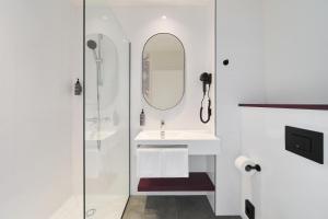 a white bathroom with a sink and a mirror at Prize by Radisson, Wroclaw Sky Tower in Wrocław +17 photos