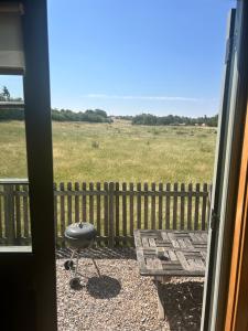 a patio with a table and a bench and a field at Astwell Mill Luxury Shepherds Hut in Helmdon +5 photos