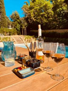 a wooden table with wine glasses and a bottle of wine at VillaGassin 403 - Luxury Villa with Private Pool near Saint-Tropez-Airco-parking in Saint-Tropez