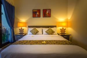 a bedroom with a large bed with two lamps at The Reika Villas by Nagisa Bali in Uluwatu