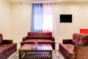 a living room with two chairs and a coffee table at Hotel O KAILASHA INN in Hasanganj